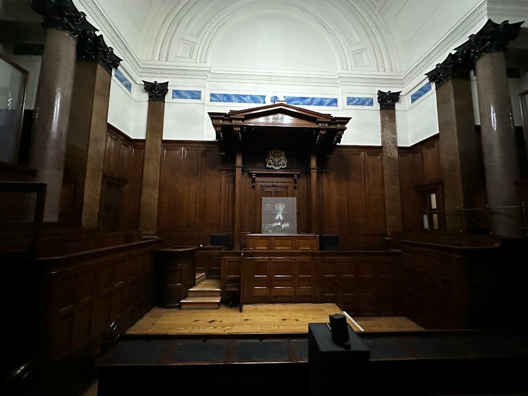 An empty courtroom with wooden paneling and columns