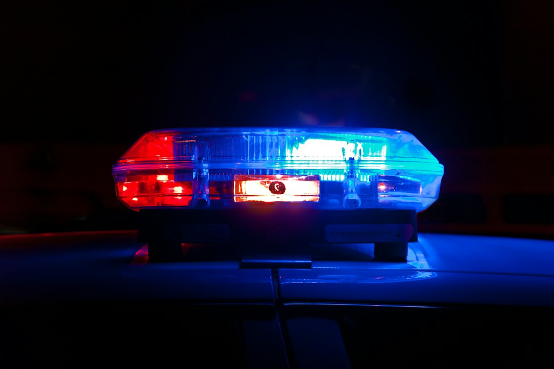 A police light bar flashing red and blue against a dark night sky