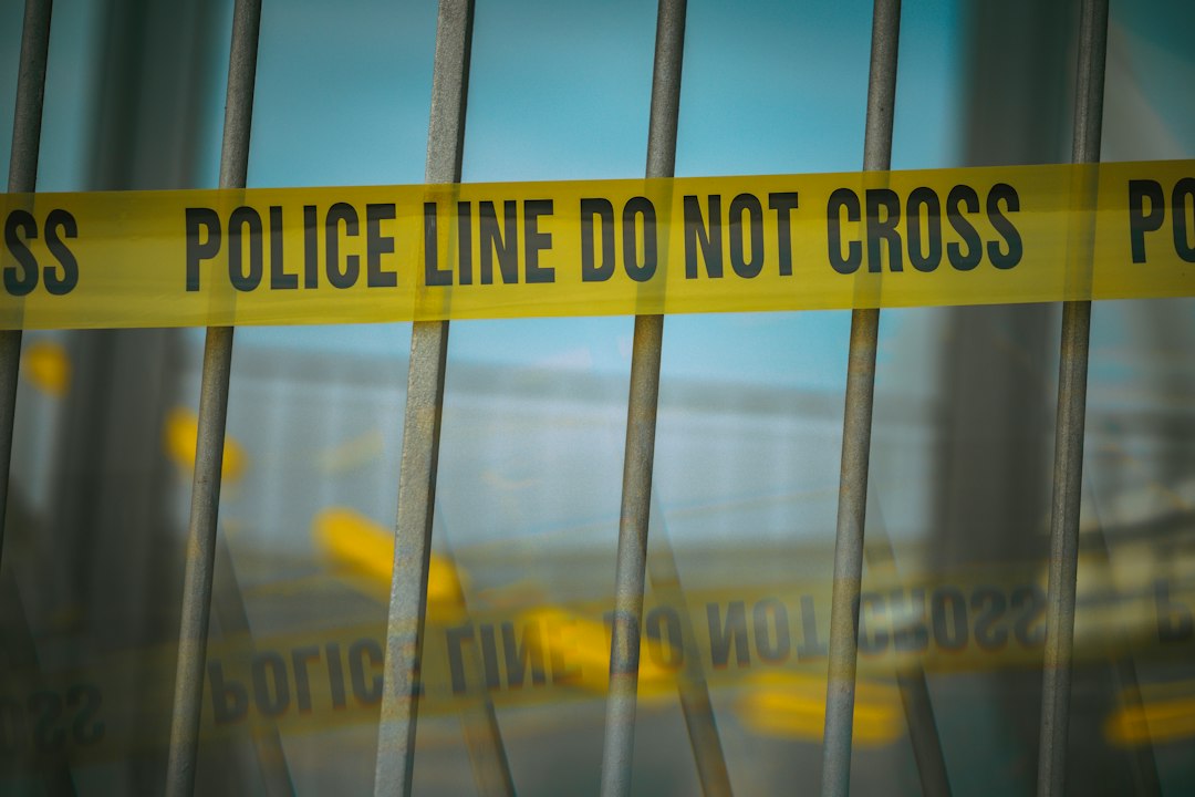 Yellow police line tape stretched across a barrier