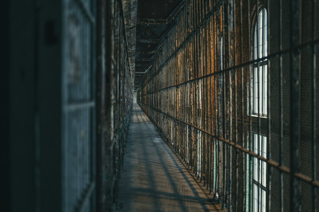 A dimly lit prison corridor lined with barred cells